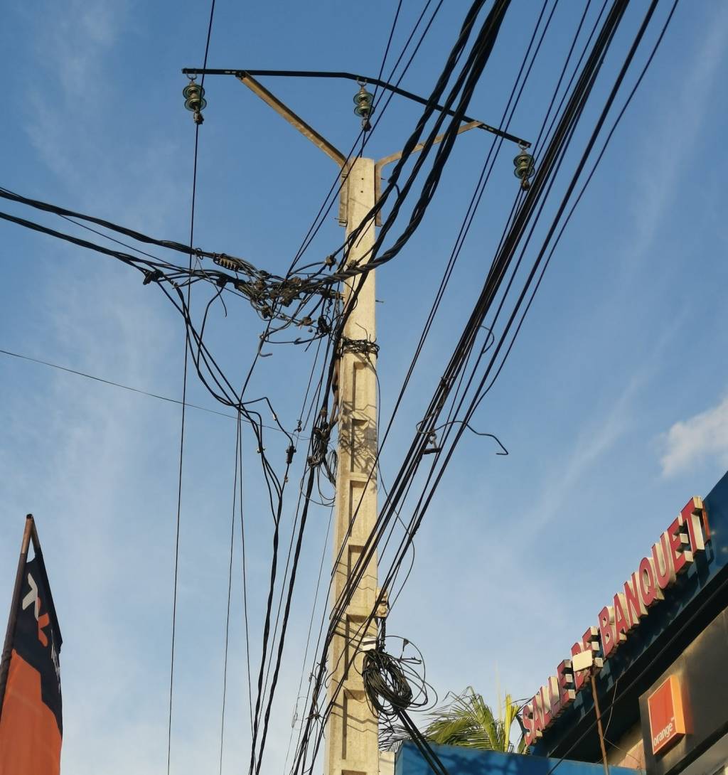 Kreuz und quer angeschlossene Kabel an einem Mast